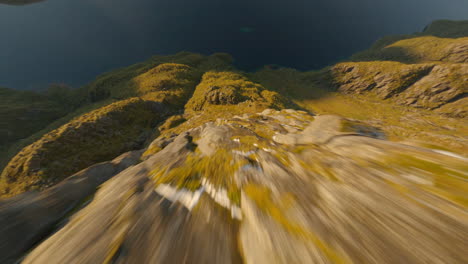 Fast-dive-of-a-mountain-emerging-from-it's-fjord,-Lofoten-Islands-in-Norway,-impressive-Cinematic-FPV-flight