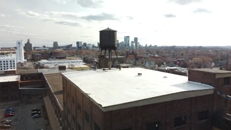 Drone-boom-reveal-of-Minneapolis-skyline-from-over-industrial-North-East-arts-district-4k