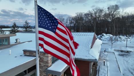 USA-flag-waving-in-winter-snow-scene-in-rural-USA