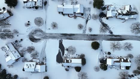 Top-down-aerial-of-residential-neighborhood-community-cul-de-sac-covered-in-winter-snow-and-ice
