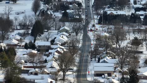 Long-aerial-zoom-of-compressed-homes-in-small-town-covered-in-winter-snow