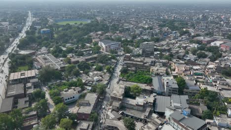 Drone-view-of-crowded-Gujranwala-city-with-jammed-streets,-cricket-stadium-and-lots-of-buildings-and-with-a-beautiful-cityscape-in-Punjab,-Pakistan