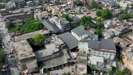 Top-profile-view-of-Cheema-Heart-Complex-surrounded-by-buildings,-houses-and-trees-in-Gujranwala-city-in-Punjab,-Pakistan