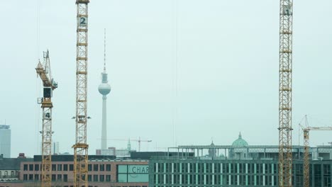 Baukräne-Ragen-über-Berlin-Auf,-Mit-Dem-Berühmten-Fernsehturm-Im-Hintergrund
