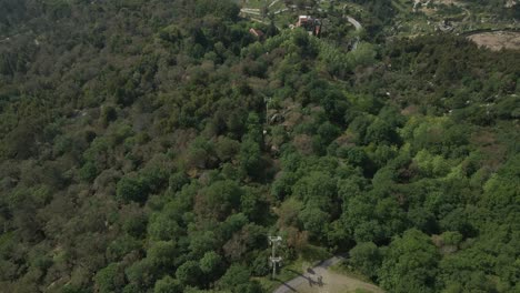 Penha-Seilbahnfahrt-über-üppigen-Wäldern,-Guimarães,-Portugal---Luftaufnahme