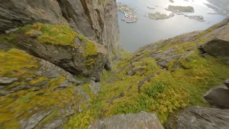 Diving-through-a-mountain-crack-in-Hamnøy,-Lofoten-Islands-in-Norway,-impressive-low-Cinematic-FPV-flight