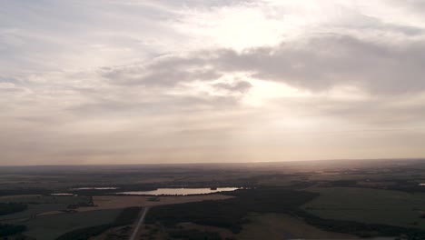 Ruhige-Landschaft-Bei-Sonnenuntergang-Mit-über-Den-Himmel-Verstreuten-Wolken,-Die-Sich-über-Ruhigem-Wasser-Spiegeln,-Luftaufnahme