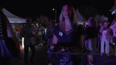 Slow-motion-shot-of-a-worker-walking-around-with-entrees-at-a-corporate-event