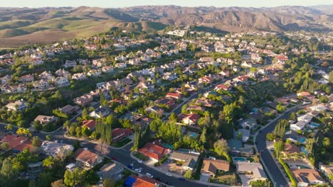 Flying-Over-Tree-Lined-Streets-of-Hidden-Hills-in-Calabasas-California,-Streets-Below-and-Mountains-on-Horizon