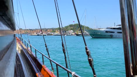Bodrum-port-view-with-luxury-yachts-from-a-big-sailing-boat-in-Turkey,-fun-summer-vacation,-moving-boat,-popular-holiday-destination,-sunny-sea-day-with-blue-sky,-4K-shot