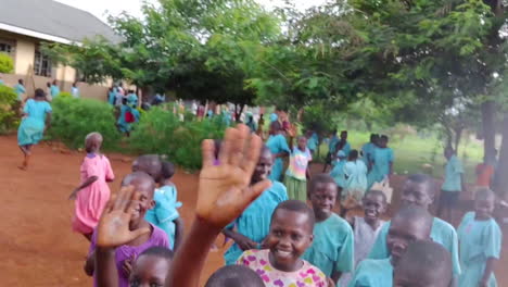 Un-Joven-Viajero-Se-Toma-Un-Selfie-Con-Un-Grupo-De-Niños-En-El-Patio-De-Una-Escuela-En-Uganda