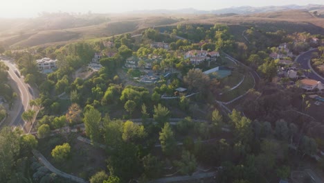 Flying-Over-Serene-Neighborhood-of-Hidden-Hills-Calabasas-in-Los-Angeles-California-at-Golden-Hour-with-Mountains-on-Horizon