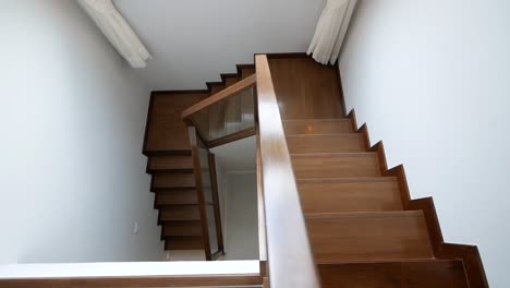 Schöne-Und-Saubere,-Glänzende-Holztreppe-Und-Weiße-Wand