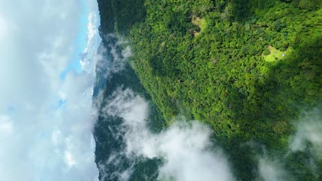 Cloud-Formation-over-Lush-Evergreen-Forest-Mountain-Landscape-of-Northern-South-East-Asia,-Flying-through-the-Clouds-Cockpit-View,-Vertical-Portrait-9:16-Video