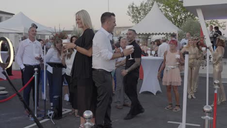 Slow-motion-shot-of-a-couple-standing-on-a-360-camera-platform-at-a-party