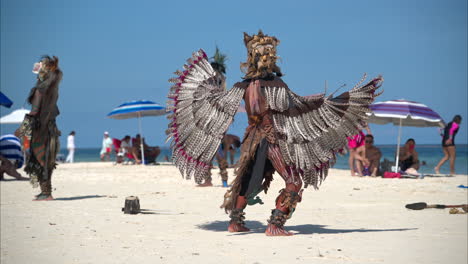 Slow-motion-of-a-latin-man-dressed-as-a-mayan-eagle-warrior-dancing-and-performing-on-a-beach-in-Mexico