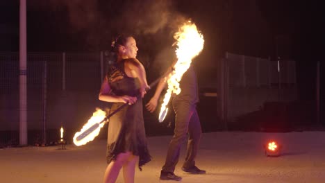 Close-up-shot-of-performers-performing-with-poles-set-on-fire-as-entertainment