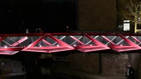 Crossing-a-red-bridge-in-Camden,-London,-United-Kingdom