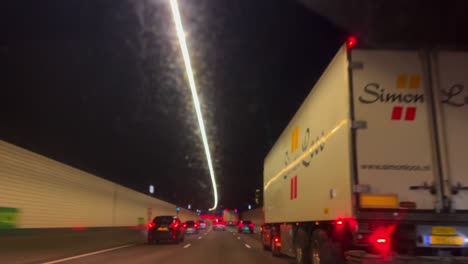 Pov-through-car-window-of-dark-tunnel-at-twilight-at-A10-highway-Amsterdam
