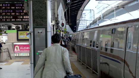 Japanese-Salaryman-Walking-Along-Station-Platform-Beside-Hokuriku-Shinkansen