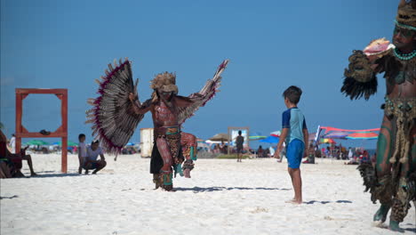 Zeitlupe-Eines-Als-Maya-Adler-Krieger-Verkleideten-Lateinamerikanischen-Mannes,-Der-An-Einem-Strand-In-Cancun,-Mexiko,-Für-Den-Touristen-Tanzt-Und-Auftritt