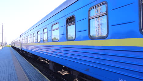 Ukrainian-Railways-Ukrzaliznycia-train-at-the-Chelm-train-station-in-Poland,-blue-yellow-train,-sunny-warm-weather,-4K-shot