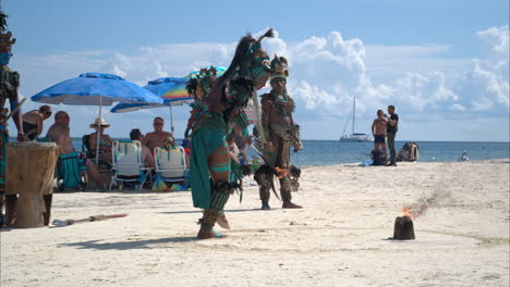 Zeitlupe-Eines-Als-Maya-Krieger-Verkleideten-Schauspielers,-Der-Am-Strand-Von-Cancun,-Mexiko,-Auftritt-Und-Seinen-Fuß-In-Flammen-Setzt