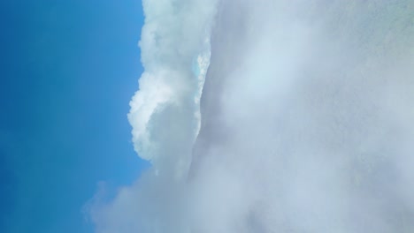 Immergrüner-Wald-Fliegt-Durch-Wolken-Und-Enthüllt-Eine-Aufnahme-Einer-Wunderschönen-Berglandschaft-Mit-Dichtem-Wald-Und-Blauem-Himmel,-Doi-Suthep-Doi-Pui-Nationalpark-Chiang-Mai,-Vertikale-4K-Social-Media,-9:16-Video
