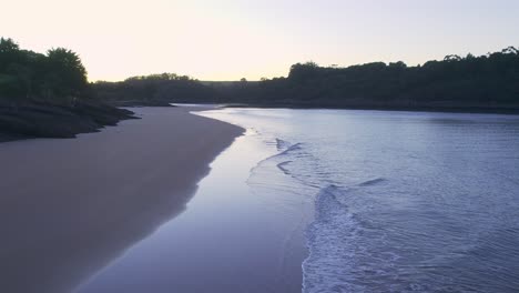 Gentle-sea-waves-on-deserted-sandy-sunset-beach-Playa-de-la-Arena,-Spain-AERIAL