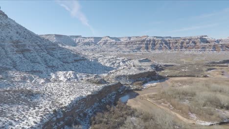 Drone-flying-through-Zion-in-Utah-featuring-snow-covered-mountains-on-a-winters-day