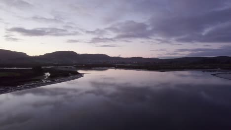 Calm-moody,-mirror-like-water-reflects-dusk-dramatic-sky-Spain-AERIAL-4K