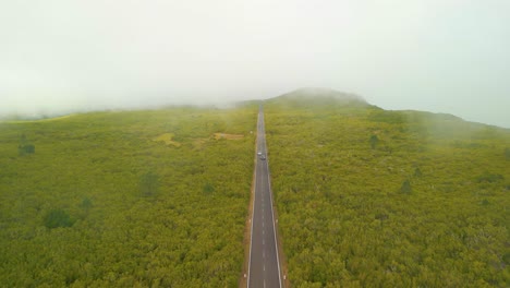 Aerial-birds-eye-shot-of-mountain-road-with-driving-Cars-during-foggy-day-in-Madeira-,-Portugal