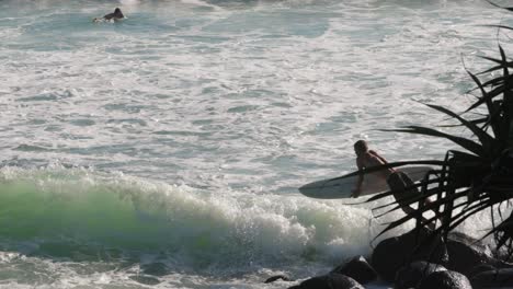 Surfista-Entrando-Al-Océano-Y-Remando-En-Un-Día-Soleado,-Burleigh-Heads,-Gold-Coast,-Australia