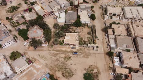 Drone-Shot-of-Nouakchott,-Mauritania---Van-Driving-Down-Dirt-Road
