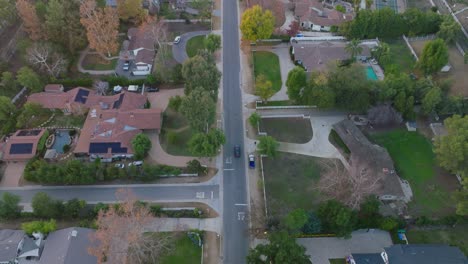 Drone-Following-Car-Driving-Down-Suburban-Street,-Upscale-Neighborhood-of-Hidden-Hills,-Calabasas-in-California