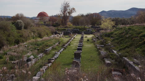 A-field-of-ancient-stones-with-a-mosque-in-the-background-in-Miletus