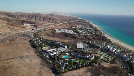 Resorts-Costeros-En-Fuerteventura,-Contrastando-Con-Paisajes-áridos,-Toma-Aérea