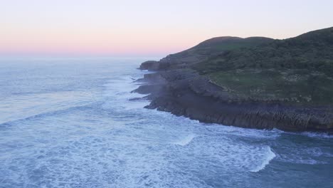 Waves-crash-on-Spains-rugged-Cantabrian-coastline-beach-sunset-DRONE