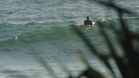 Surfer-waiting-for-waves-on-a-sunny-day,-Burleigh-Heads,-Gold-Coast,-Australia