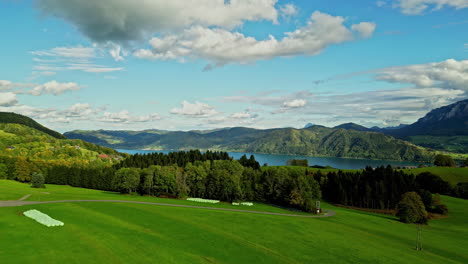 Pristine-mountain-lake-valley-with-green-fields,-blue-sky-and-forests