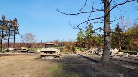 Abandoned-rural-landscape-after-wildfire,-burned-cars,-trees-in-Alberta-Canada