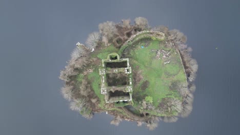 Aerial-view-of-McDermott-Castle-ruins-on-an-island-in-Lough-Key,-Roscommon,-Ireland,-with-surrounding-water