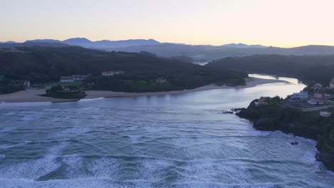 Tidal-water-recedes-from-coastal-Ria-flooded-valley-Spain-sunset-AERIAL