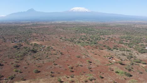Traditional-Masai-farms-on-savanna-at-footstep-of-Mount-Kilimanjaro,-aerial-view
