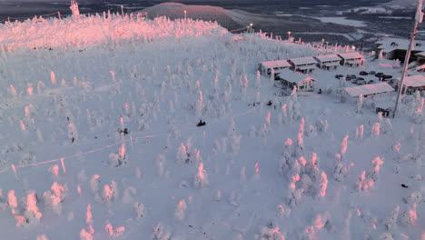 Aerial-view-around-a-snowmobiles-on-top-of-Iso-Syote-fell,-sunrise-in-Finland
