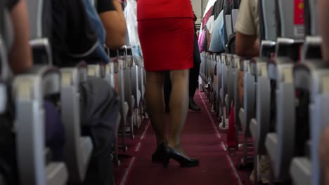 Medium-view-of-air-hostess-or-flight-attendant-in-red-suit-holding-opaque-trash-bag