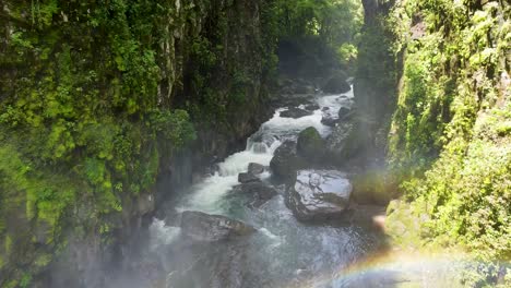 Aerial-footage-flying-through-waterfall-mist-over-atmospheric-lush-green-ravine