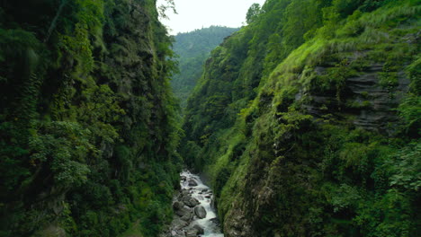 Nepals-Faszinierende-Verborgene-Schönheit-Der-Landschaft,-Fluss,-Der-Zwischen-Hügeln-Fließt,-Landschaft-Mit-Grün,-Bäumen,-Felsen,-Filmische-Drohnenaufnahme-4k