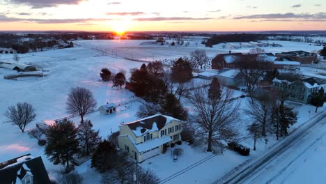 Two-story-homes-along-rural-country-road-in-winter-snow-scene-at-sunrise
