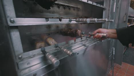 Cook-inspecting-meat-from-restaurant-oven
